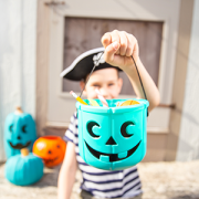 boy dressed as pirate holding a teal pumpkin