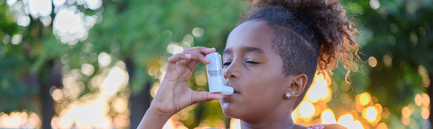 girl using asthma inhaler