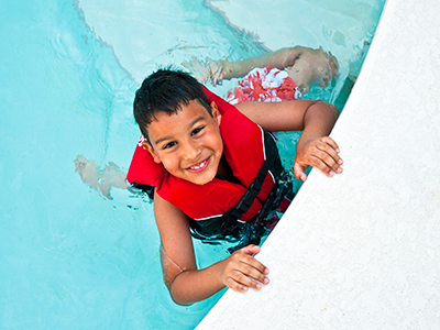 boy wearing a life jacket in swimming pool