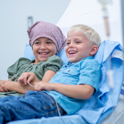 child with cancer and sibling in hospital bed