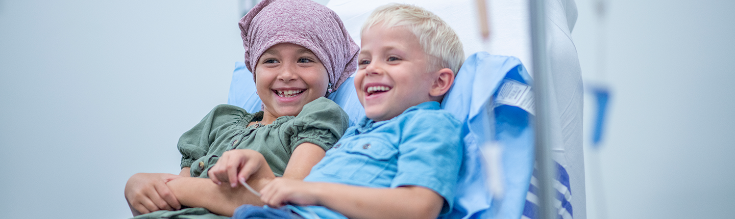 child with cancer and sibling in hospital bed