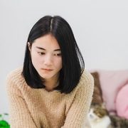 Teen girl sitting on bed unhappy