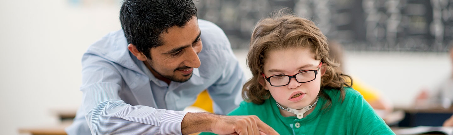 Teacher helping student in special education class