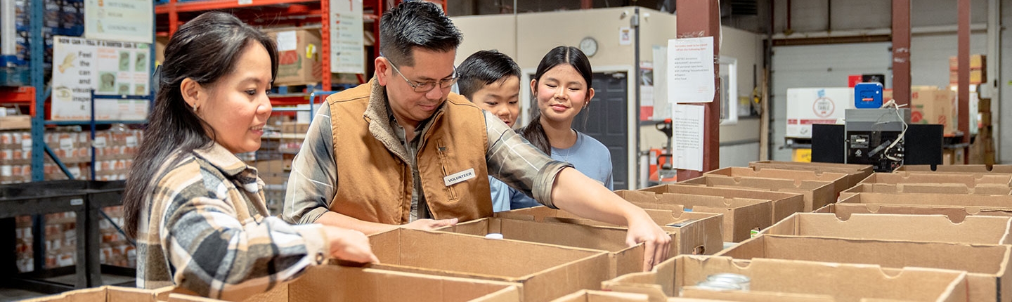 Family packing boxes at a food bank