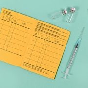 yellow vaccine card with syringes and vials