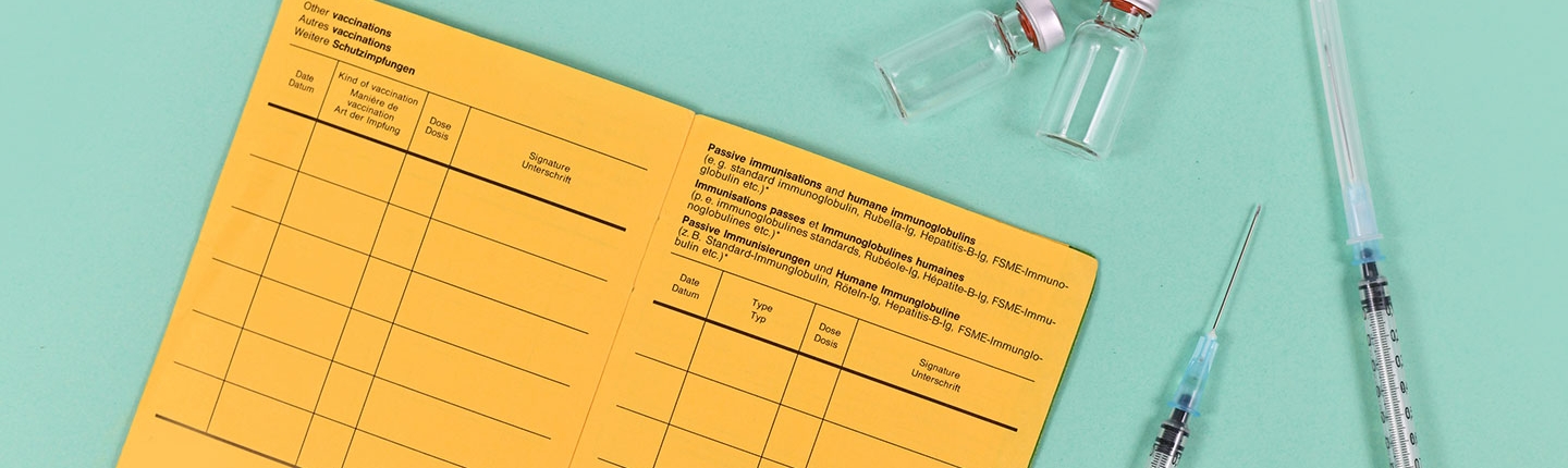 yellow vaccine card with syringes and vials