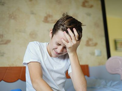 Young boy holding his head