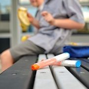Epi-pen sitting on a bench with a kid in the background