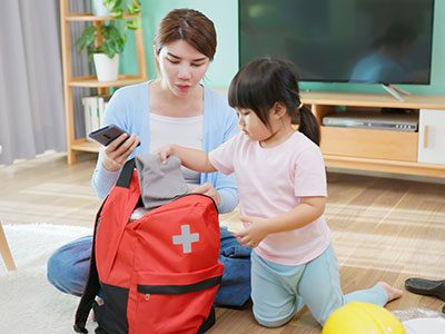 mother and daughter packing emergency kit