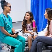 Little girl with arm cast talking to a doctor