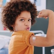 boy flexing after receiving a vaccine
