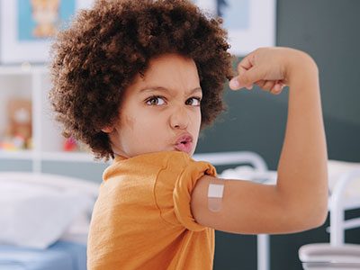 boy flexing after receiving a vaccine