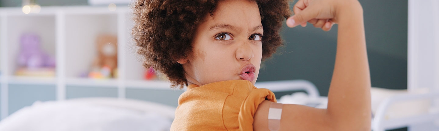 boy flexing after receiving a vaccine