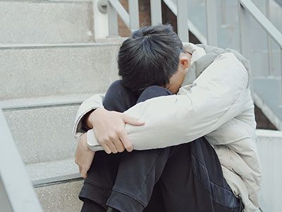 sad boy hugging his legs