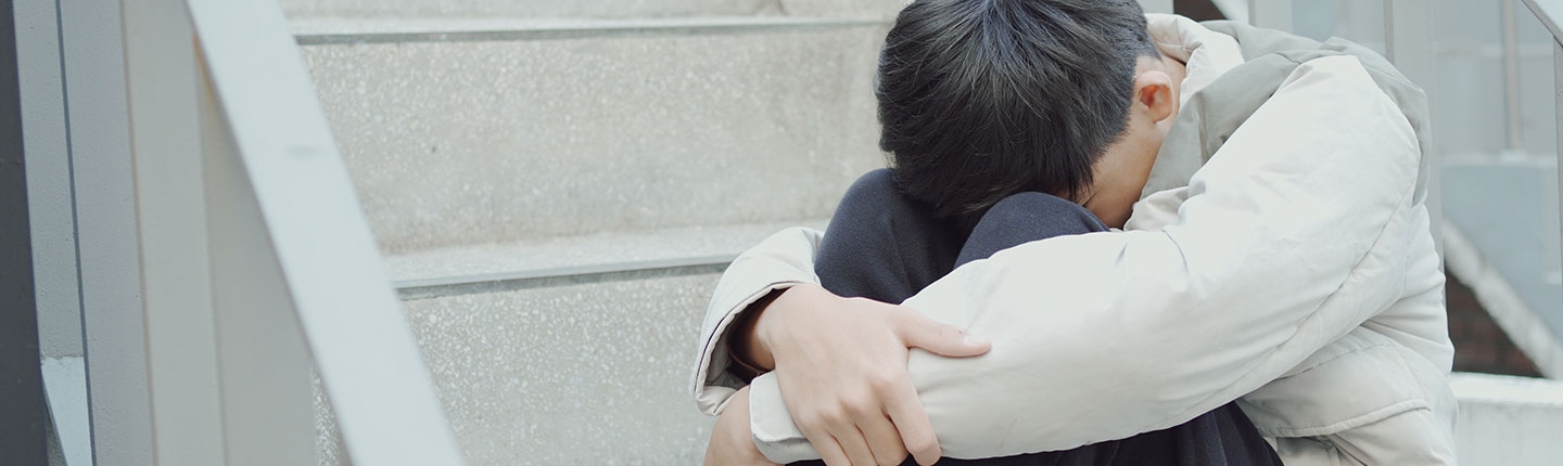 sad boy hugging his legs