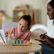 young girl painting with an adult woman