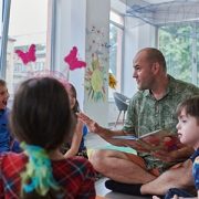 teacher reading a book to children in an elementary school or kindergarten