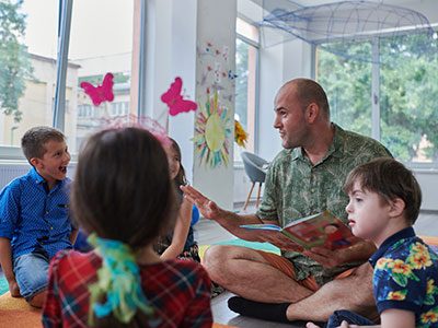 teacher reading a book to children in an elementary school or kindergarten
