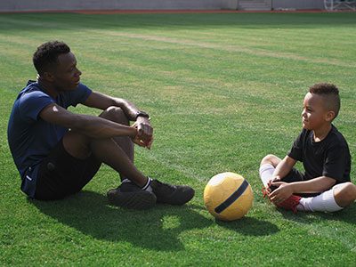 Parent and young athlete talking