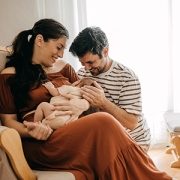 Parents cuddling newborn baby