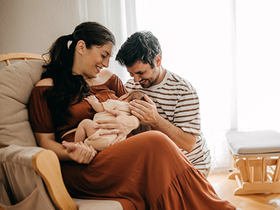 Parents cuddling newborn baby