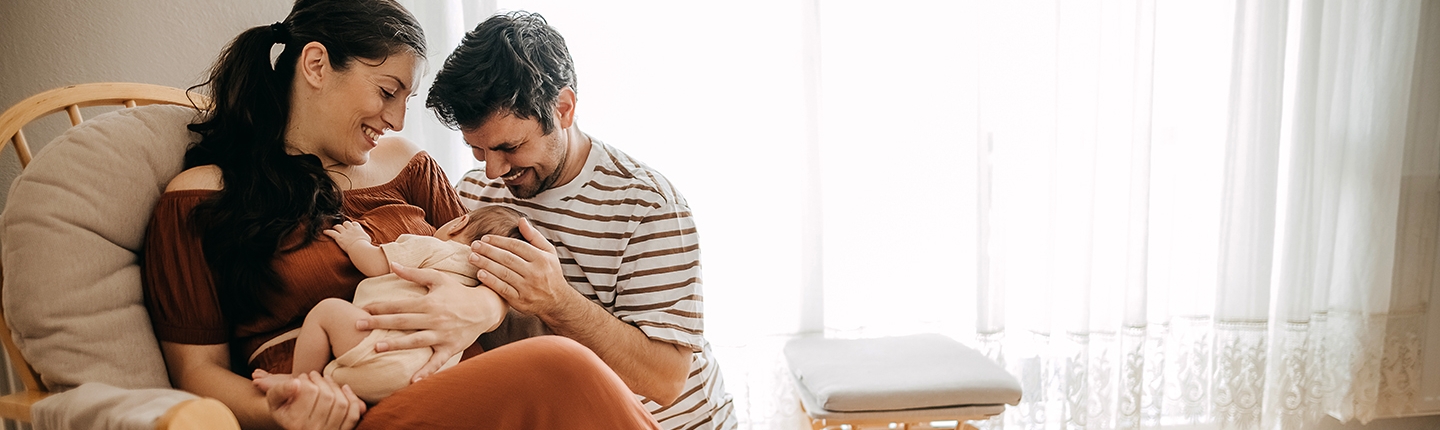 Parents cuddling newborn baby