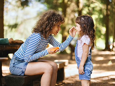 Mother putting sunscreen on child.