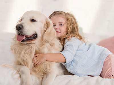 young girl hugging dog