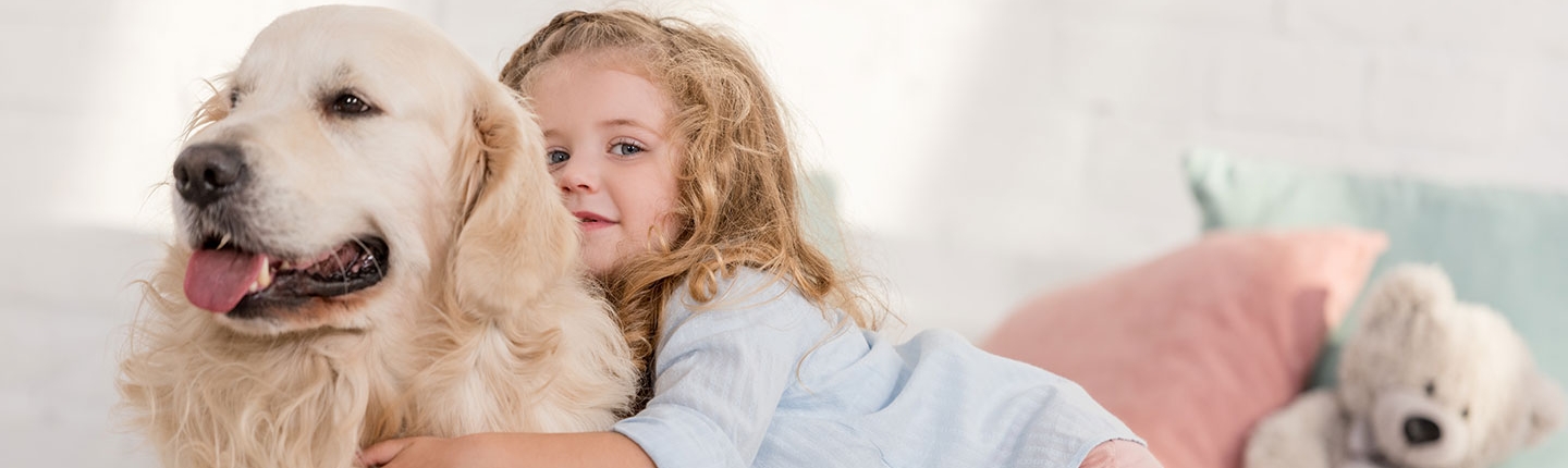 young girl hugging dog