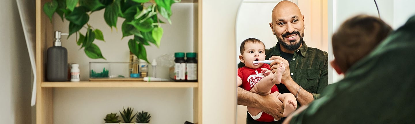 dad brushing baby's teeth