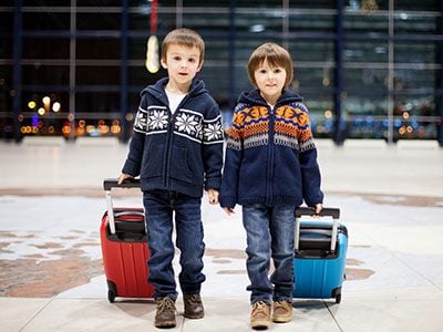 two brothers with suitcases at the airport